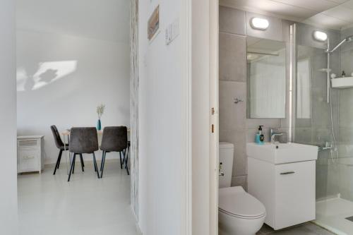 ein weißes Badezimmer mit Toilette und Waschbecken in der Unterkunft Elisabeth Salt Lake views 200m from Makenzy beach in Larnaka