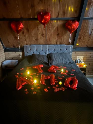 a bed with red hearts and candles on it at Cabana Recanto nas Montanhas in Lindóia