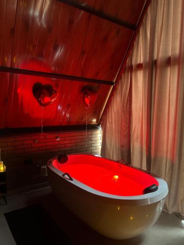 a red bath tub in a bathroom with red lights at Cabana Recanto nas Montanhas in Lindóia