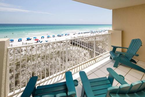 a balcony with chairs and the beach and the ocean at Gulf Side 402 Pet friendly gulf front condo in Fort Walton Beach