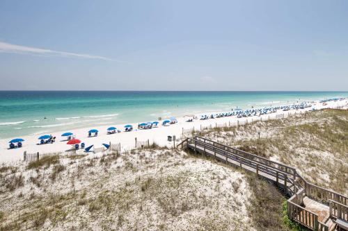a beach with a bunch of umbrellas and the ocean at Gulf Side 402 Pet friendly gulf front condo in Fort Walton Beach