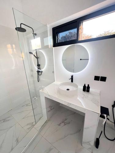 a white bathroom with a sink and a shower at Furaha Villa Zanzibar in Kiwengwa