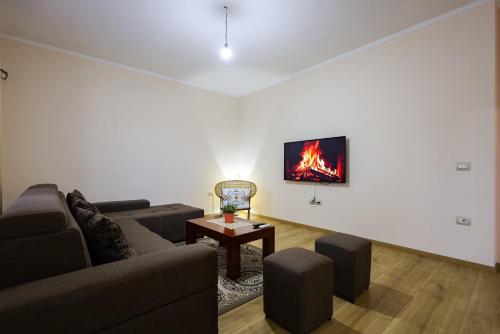 a living room with a couch and a table and a tv at Apartment with garden in the center of Durres in Durrës