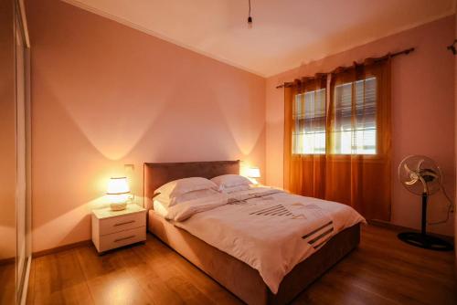 a bedroom with a large bed and a window at Apartment with garden in the center of Durres in Durrës