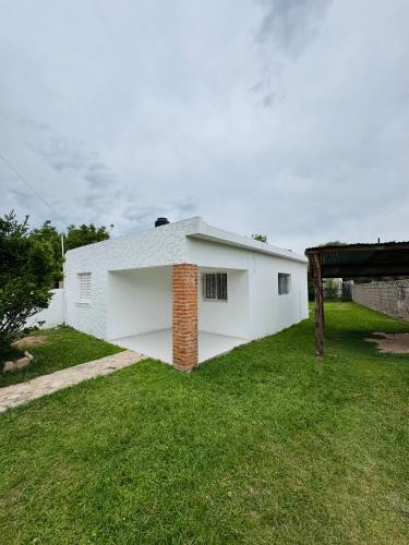 a white house with a brick chimney in a yard at Casa en Nono traslasierra in Nono