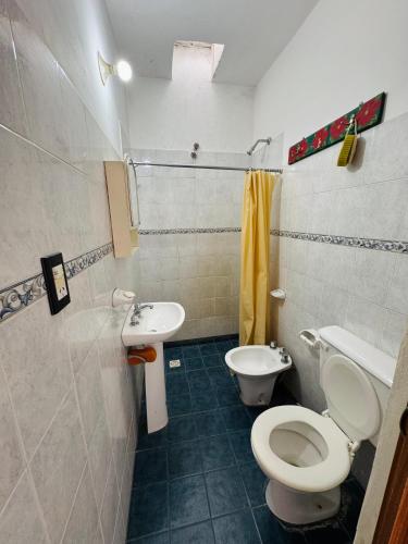 a bathroom with a toilet and a sink at Casa en Nono traslasierra in Nono