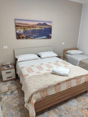a bedroom with two beds and a painting on the wall at Casa vacanze Carmen House in Ercolano
