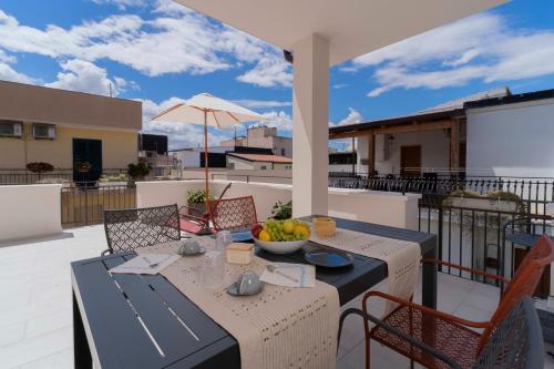 a table with a bowl of fruit on a balcony at Dimora Fortunato in Bernalda