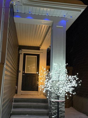 a vase with christmas lights in front of a door at Almost Heaven - Cozy 2BDRM APT near Heritage Park,Spruce Meadows & Banff-SW Calgary in Calgary