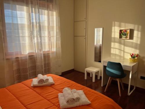 Un dormitorio con una cama, un escritorio y una silla. en La casetta di Memy, en Nápoles