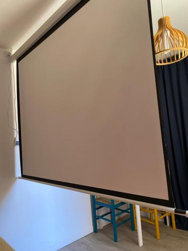 a large white screen sitting on top of a wall at Le petit soleil, 5 mn de la plage et de l'embarcadère, parking et wifi gratuits in Toulon