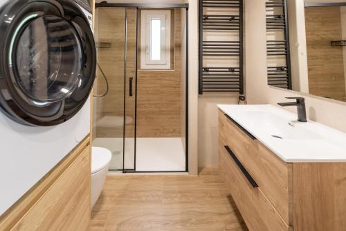 a bathroom with a washing machine and a sink at Las casitas de mache - LAGOSSA in Cerler