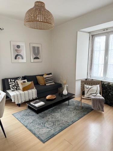 a living room with a black couch and a table at Central Lisbon Apartment in Mouraria in Lisbon