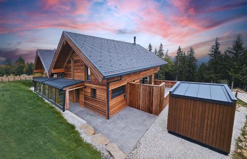 a log cabin with a fence and a solarium at The Lodges am Klippitztörl - Chalet in Klippitztorl