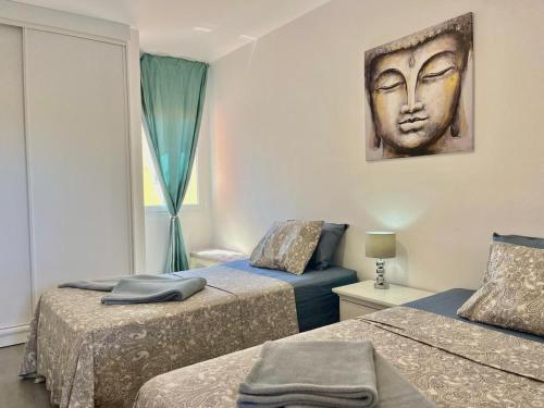 a bedroom with two beds with a head on the wall at Oasis Penthouse Maspalomas in Maspalomas
