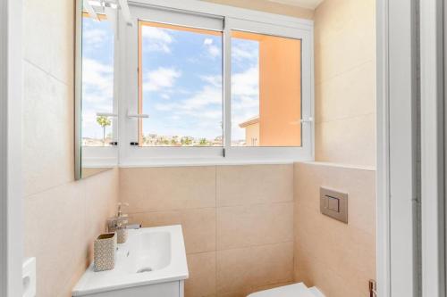 a bathroom with a sink and a window at Oasis Penthouse Maspalomas in Maspalomas