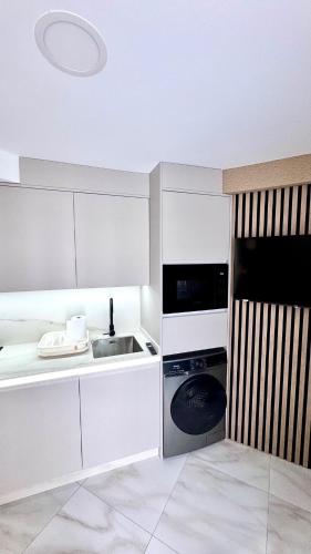 a white kitchen with a sink and a stove at Las Americas 200A apartment in Costa de Adeje