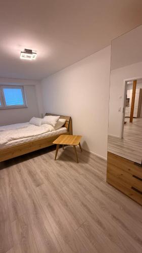a bedroom with a bed and a wooden table at Ferienwohnung im Ellertal in Bockelnhagen