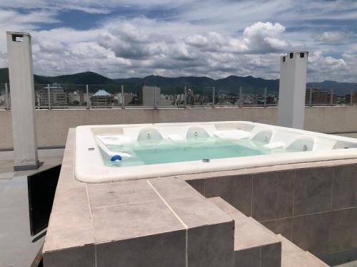 萨尔塔Monoambiente Bambú, Nuevo, amplio y cómodo的建筑物屋顶上的热水浴池