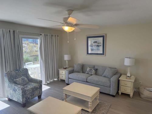 un salon avec un canapé et une chaise dans l'établissement Island Sands 103 Gulf front condo, à Fort Walton Beach