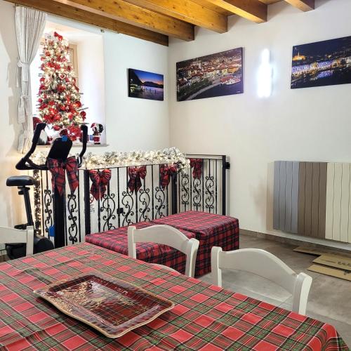 a room with a christmas tree and a table and chairs at Eva Lake Endine Hospitality in Endine Gaiano