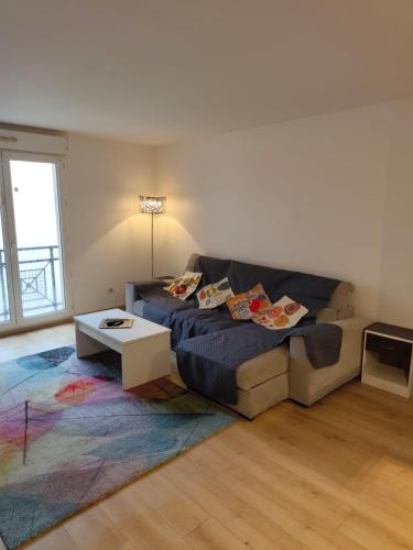 Charmant 3 pieces 2 chambres et parking في بونتولت-كومْبو: غرفة معيشة بها أريكة وطاولة