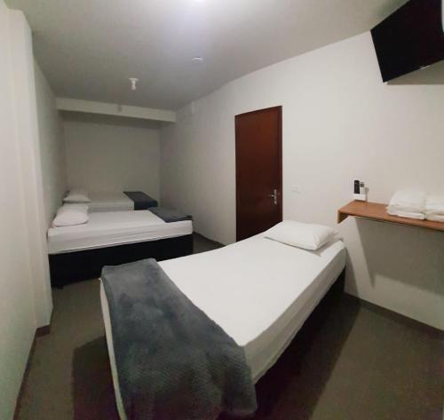 two beds in a small room with at Emas hotel in Mineiros
