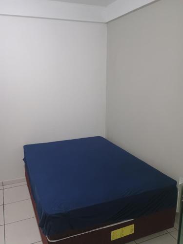 a bed with a blue mattress in a room at Apartamento zimbros bombinhas in Bombinhas