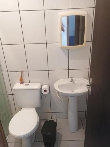 a small bathroom with a toilet and a sink at Apartamento zimbros bombinhas in Bombinhas