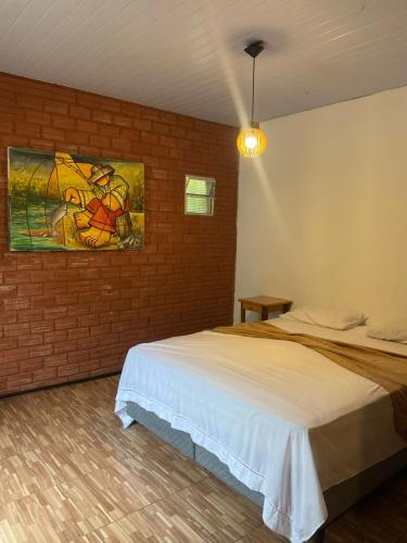 a bedroom with a bed and a painting on the wall at MOVE quartos de hotel in Pipa