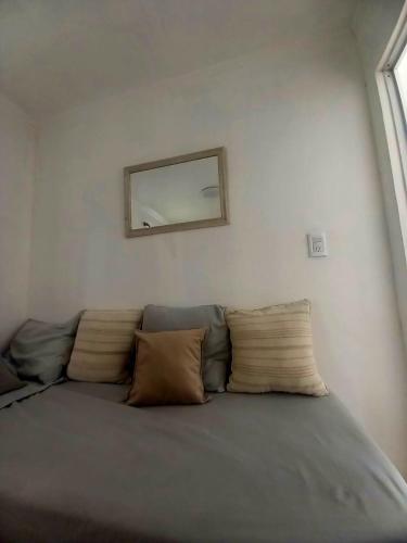 een bank in een kamer met een spiegel aan de muur bij Viento Sur 2 in Estancia El Polomo