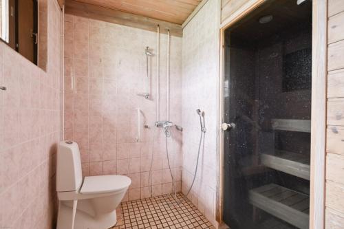 een badkamer met een douche, een toilet en een glazen deur bij Dávidi talo 