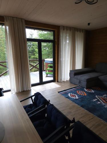 a living room with a couch and a large window at Спас Резорт in Spas