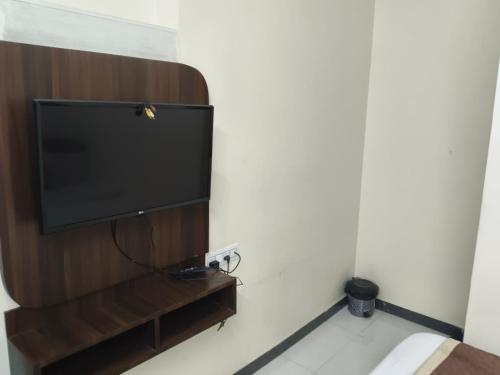 TV de pantalla plana en la pared en Hotel Grande Inn, en Udaipur