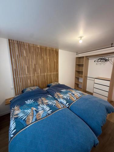 a bedroom with a blue bed with a blue comforter at Au Petit Casino in Vuillafans