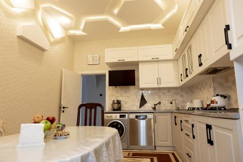 una cucina con mobili bianchi e un piano di lavoro di SkyGate Guesthouse 