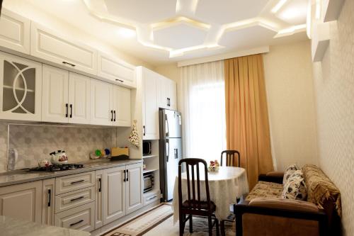 SkyGate Guesthouse : مطبخ مع دواليب بيضاء وطاولة في الغرفة