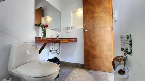 a bathroom with a white toilet and a wooden sink at Hotel Parador del Gitano in Doradal
