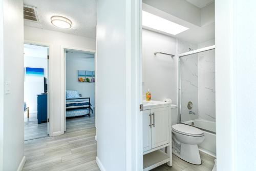 a white bathroom with a toilet and a shower at 2bd 2ba Beachside E 3Min to Beach Pool! in Clearwater Beach