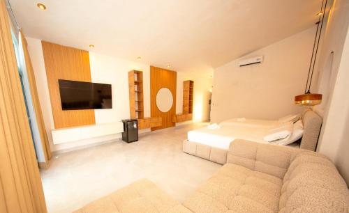 a bedroom with a bed and a couch and a tv at Sababa Resort El paredon in El Paredón Buena Vista
