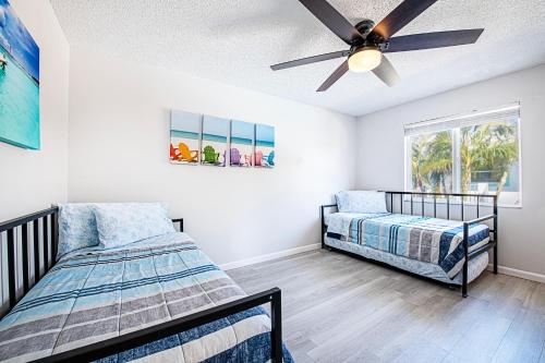 a bedroom with two beds and a ceiling fan at 2bd 2ba Beachside E 3Min to Beach Pool! in Clearwater Beach