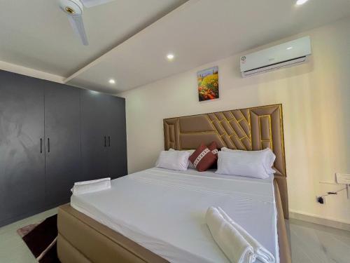 ein Schlafzimmer mit einem großen Bett mit weißer Bettwäsche in der Unterkunft Madzo Holiday homes in Mombasa