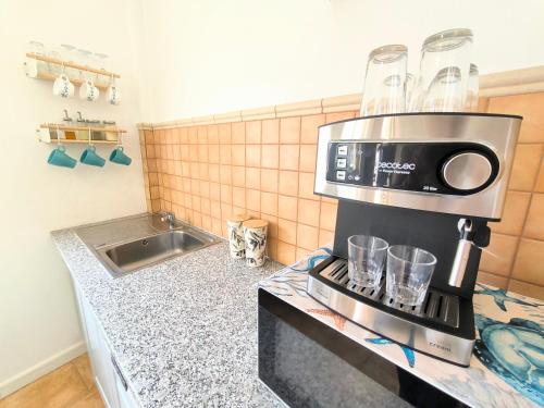 una cucina con macchinetta del caffè su un bancone di Casa Dace Renovated Studio - Fast Wi-Fi, Near Ocean, Ideal for Long Stays a San Nicolás