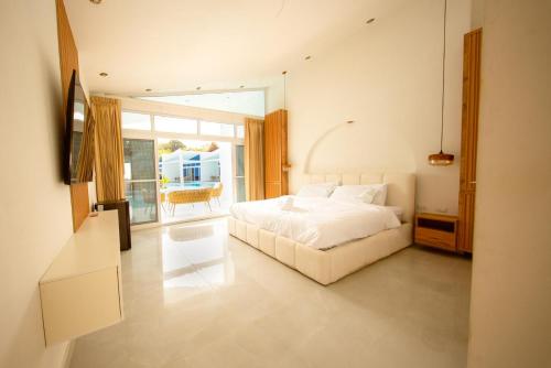 a bedroom with a white bed and a large window at Sababa Resort El paredon in El Paredón Buena Vista