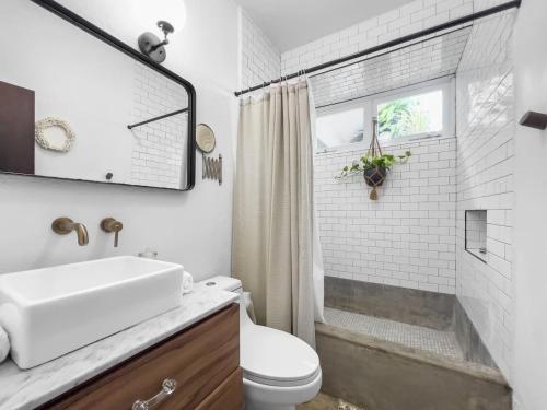 a white bathroom with a sink and a toilet at Marley n Enzos Surf Shack in Aguadilla