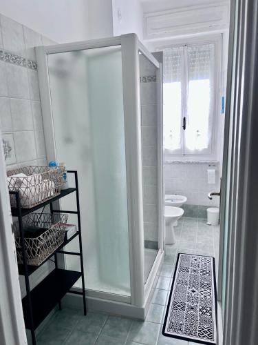 a white bathroom with a shower and a toilet at Mavin Apartments Cuneo in Cuneo