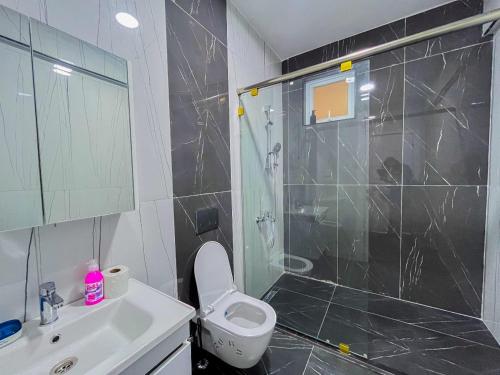 ein Badezimmer mit Dusche, Toilette und Waschbecken in der Unterkunft Madzo Holiday homes in Mombasa