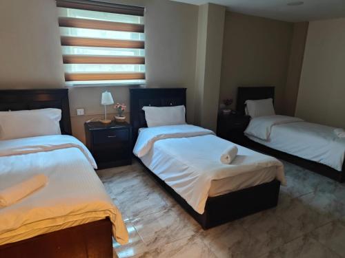 Ένα ή περισσότερα κρεβάτια σε δωμάτιο στο Kahraman Amman Hotel