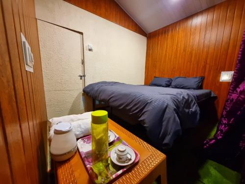 Pawan leke cottage في Kolvan: غرفة صغيرة بها سرير وطاولة