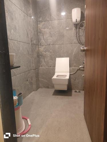 a bathroom with a white toilet in a room at Hotel VR Villa in Vadodara